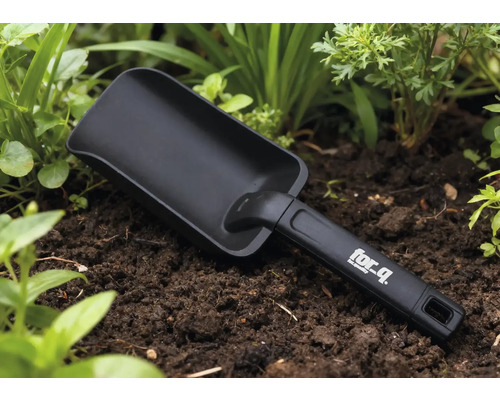 Lo পেটopată de grădină în stratul de flori cu logo-ul for_q pe mâner