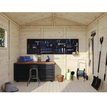 Atelier luminos cu banc de lucru, perete cu scule și unelte de grădină