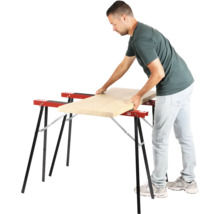 Bărbat așezând o scândură de lemn pe doi capre de lucru