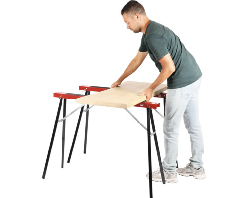 Bărbat așezând o scândură de lemn pe doi capre de lucru