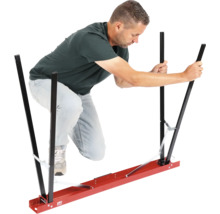 Un bărbat manevrează un ajutor de transport pentru plăci de gips-carton