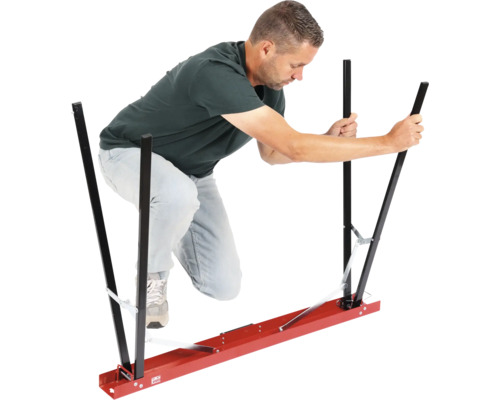 Un bărbat manevrează un ajutor de transport pentru plăci de gips-carton