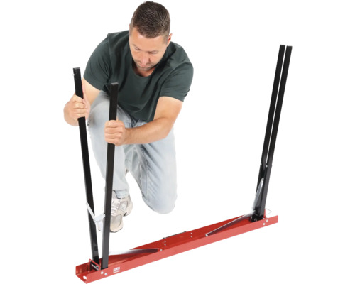 Un bărbat asamblează un ajutor de montaj pentru geamuri auto.