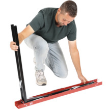 Bărbat asamblând un șablon metalic de tăiere a plăcilor pentru plăci mari