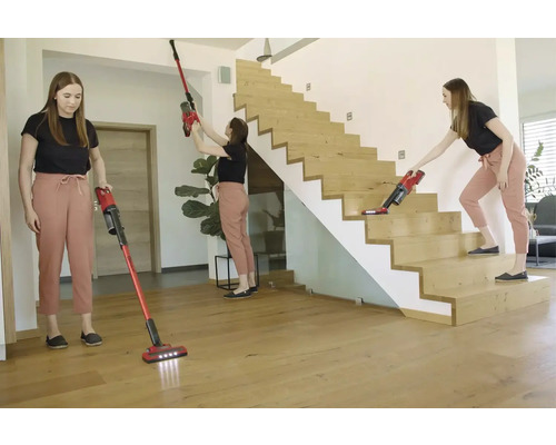 O femeie folosește un aspirator fără fir pentru a curăța podeaua, tavanul și scările.