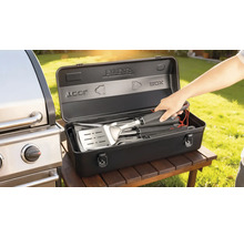 Set de ustensile pentru grătar într-o cutie de depozitare neagră lângă un grătar