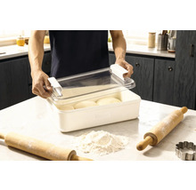 Recipient pentru aluat cu capac și două sucitoare plus făină pe un blat de bucătărie