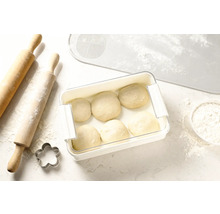 Aluat în cutie de prospețime lângă sucitor, formă de tăiat biscuiți și suport de aluat