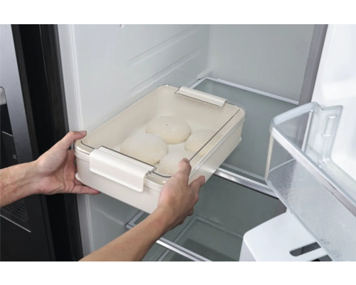 Persoană care pune un vas cu aluat cu capac în frigider