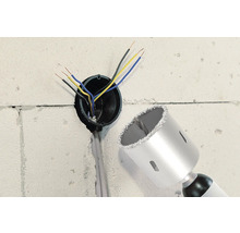 Perete cu gaură, cabluri electrice și o carotă.