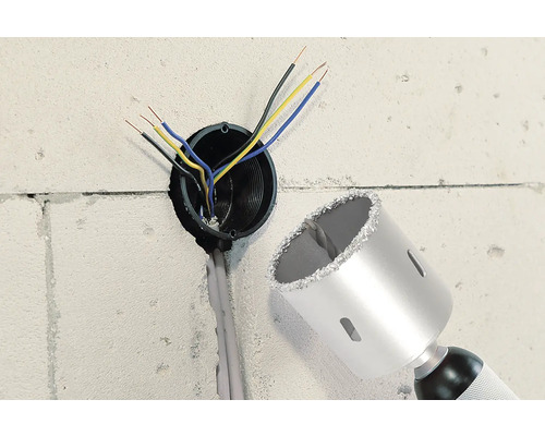 Perete cu gaură, cabluri electrice și o carotă.