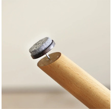 Protecție din pâslă cu cui pe un picior de mobilă din lemn