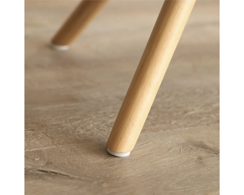 Prim-plan cu un picior de mobilă din lemn, cu protecție pentru podea.