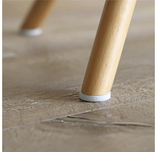 Imagine detaliată cu un picior de scaun cu protecție pentru podea pe o podea din lemn.