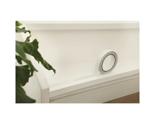 O rolă de bandă adezivă dublu față pe o suprafață.