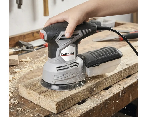 O mână operează un șlefuitor excentric Pattfield pe o scândură de lemn.