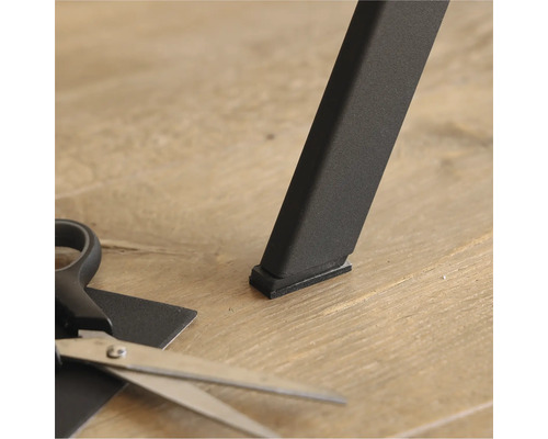 Glisor de mobilier sub un picior de masă și o foarfecă pentru tăiere la dimensiune