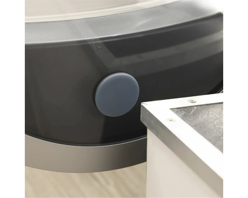 Detaliu al unei mașini de spălat cu un dop de închidere rotund, gri