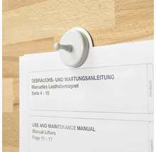 Cârlig magnetic care ține un manual de utilizare pe o suprafață de lemn