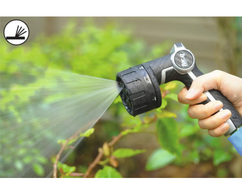 O persoană ține un pistol de pulverizare pentru grădină care pulverizează apă