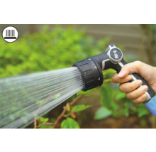 Mână ținând pistolul de stropit grădină în timpul udării