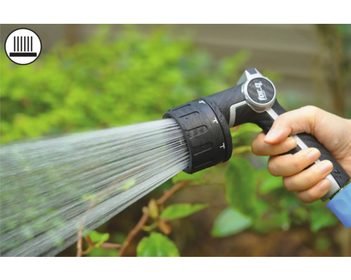 Mână ținând pistolul de stropit grădină în timpul udării