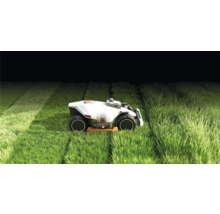 Robot de tuns iarba în funcțiune pe un gazon.