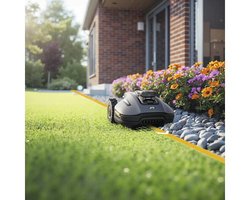 Robot de tuns iarba pe gazon în fața casei