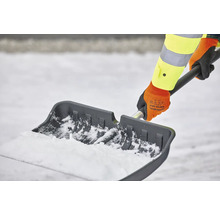 Persoană care curăță zăpada cu o lopată de zăpadă