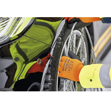 Montarea lanțurilor de zăpadă pe anvelopa unei mașini cu mănuși.