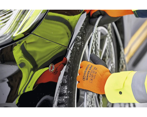 Montarea lanțurilor de zăpadă pe anvelopa unei mașini cu mănuși.