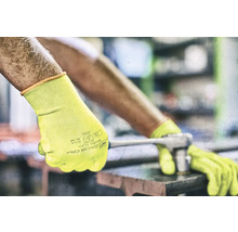 Bărbat cu mănuși de lucru galbene folosind o cheie fixă