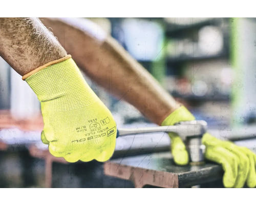 Bărbat cu mănuși de lucru galbene folosind o cheie fixă