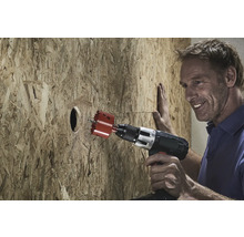 Bărbat care găurește o placă de lemn cu un ferăstrău circular.