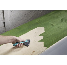 O scândură de lemn este vopsită cu un instrument de vopsire.