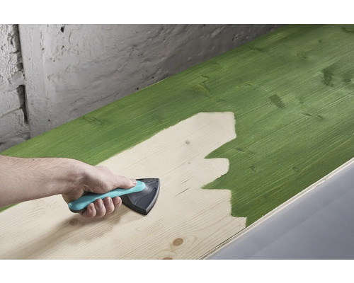 O scândură de lemn este vopsită cu un instrument de vopsire.