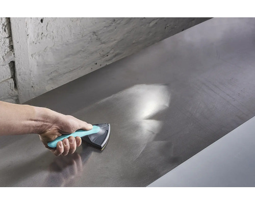 Mână care folosește un bloc de șlefuire pentru a netezi o suprafață metalică.