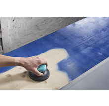 O persoană șlefuiește o suprafață de lemn albastră cu un șlefuitor excentric.