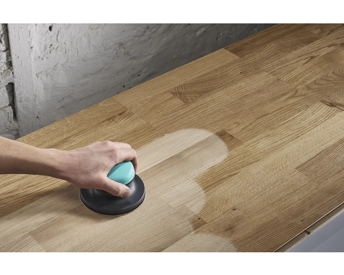 O persoană șlefuiește o placă de lemn cu un șlefuitor excentric.