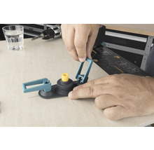 Un bărbat manevrează un tăietor circular cu ferăstrău pe o suprafață de lemn