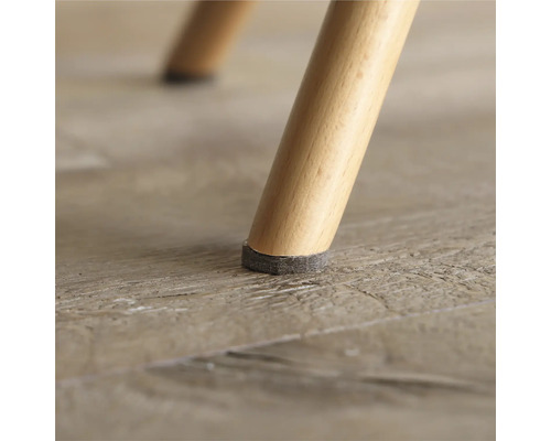 Prim-plan cu un picior de scaun cu alunecător din pâslă pentru a proteja podeaua.