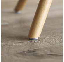 Prim-plan cu picior de scaun din lemn cu alunecător din pâslă pe o podea din lemn