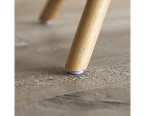 Prim-plan cu picior de scaun din lemn cu alunecător din pâslă pe o podea din lemn