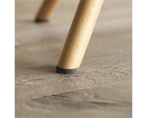 Prim-plan cu picior de scaun cu protecție din pâslă pe podea de lemn