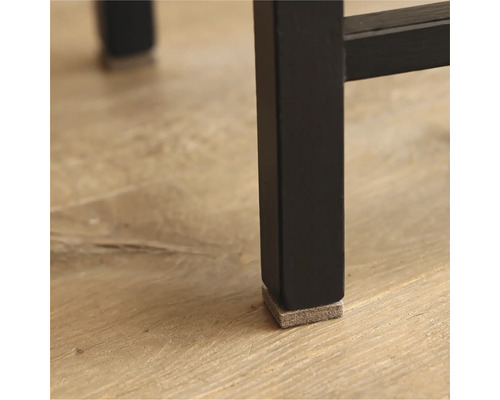 Prim-plan cu picior negru de mobilă, cu alunecător din pâslă pentru protecția podelei.