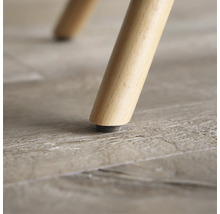 Prim-plan cu picior de mobilă din lemn cu protecție pentru podea.