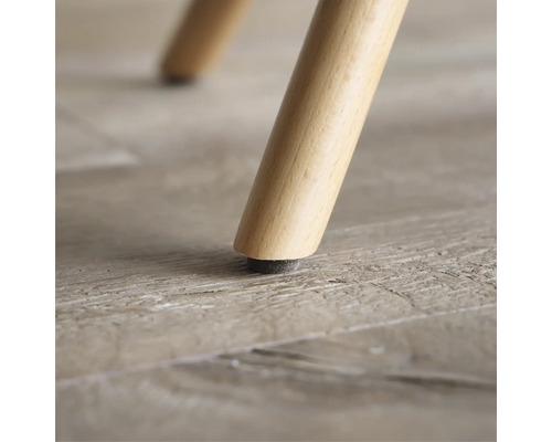 Prim-plan cu picior de mobilă din lemn cu protecție pentru podea.