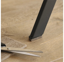 Glisor din pâslă pe un picior de scaun cu foarfecă și bucată de pâslă pe podea