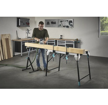 Bărbat frezând lemn pe un banc de lucru cu cleme cu șurub într-un atelier