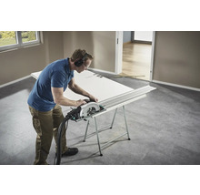 Artizan taie o ușă cu un ferăstrău circular pe un banc de lucru.